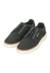 Black canvas shoes with a low-top design, featuring white rubber soles, metal eyelets, and a striped interior lining. Logo displayed on the side.