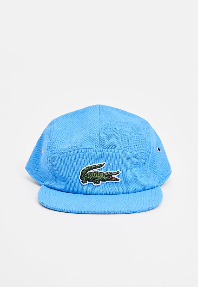 Blauwe katoenen pet met een vlakke rand, voorzijde geborduurd met een groen krokodillenlogo en versterkte oogjes voor ventilatie.