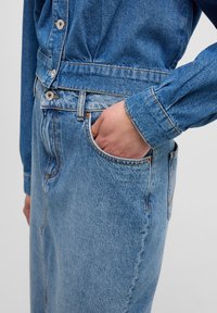 Jeanskjol med hög midja, ljusblå tvätt, sidofickor och kontrasterande sömmar. Mjuk textur med rak silhuett.