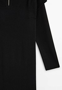 Robe noire en maille à manches longues avec un col montant côtelé et un détail de fermeture éclair à l'avant sur fond blanc.