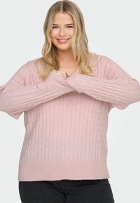 Svetlo rožnata pletiva pulover z dolgimi rokavi in ribanim robom, ki ima sproščen kroj in mehak teksturo.