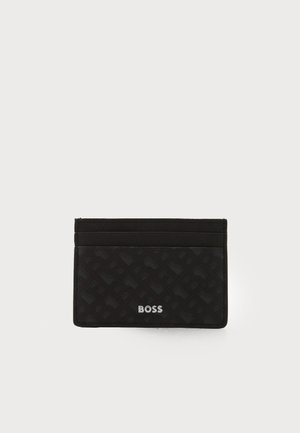 Black card holder made of textured material featuring a woven pattern, with two card slots and a metallic brand logo on the front.