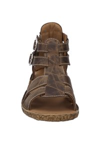 Brązowe skórzane sandały z otwartym noskiem, kilkoma paskami, srebrnymi akcentami oraz teksturowaną podeszwą.