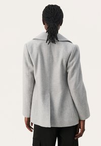 Grå uldblandingsblazer med en notch-krave, strukturerede skuldre og lange ærmer. Har en lige bagsøm og sidelommer.