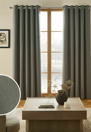 Gray blackout curtains hanging on a metal rod over a large multi-pane window with a wooden coffee table below.