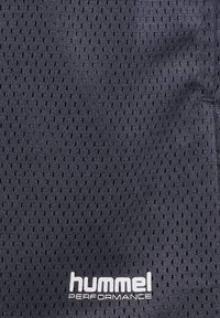 Nätatletisk tyg i mörk marinblått med en perforerad textur. Har en vit "hummel PERFORMANCE" logotyp längst ner.