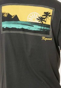 Maglietta nera con stampa grafica di montagne, un tramonto e palme nei colori giallo, turchese e nero. Logo "Ripcurl" in giallo.