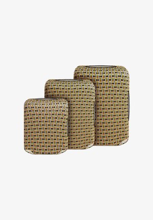 Trzy walizki w zestawie o zaokrąglonych krawędziach, z geometrycznym wzorem w kolorach żółtym, czarnym i pomarańczowym na białym tle.