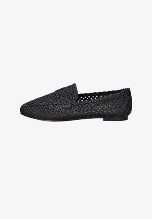 Black woven loafer with scalloped edges and braided details, flat sole, and closed toe.