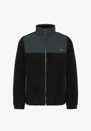 Flis jakna s patentnim zatvaračem sprijeda, visokim ovratnikom, crnim strukturiranim tijelom i glatkim tamnosivim panelom na vrhu. Istaknut logotip na prsima.