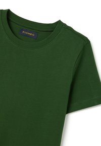 Grünes Baumwoll-T-Shirt mit rundem Ausschnitt, versehen mit einem Etikett, auf dem "PIOMBO" steht. Der Stoff wirkt glatt und weich.