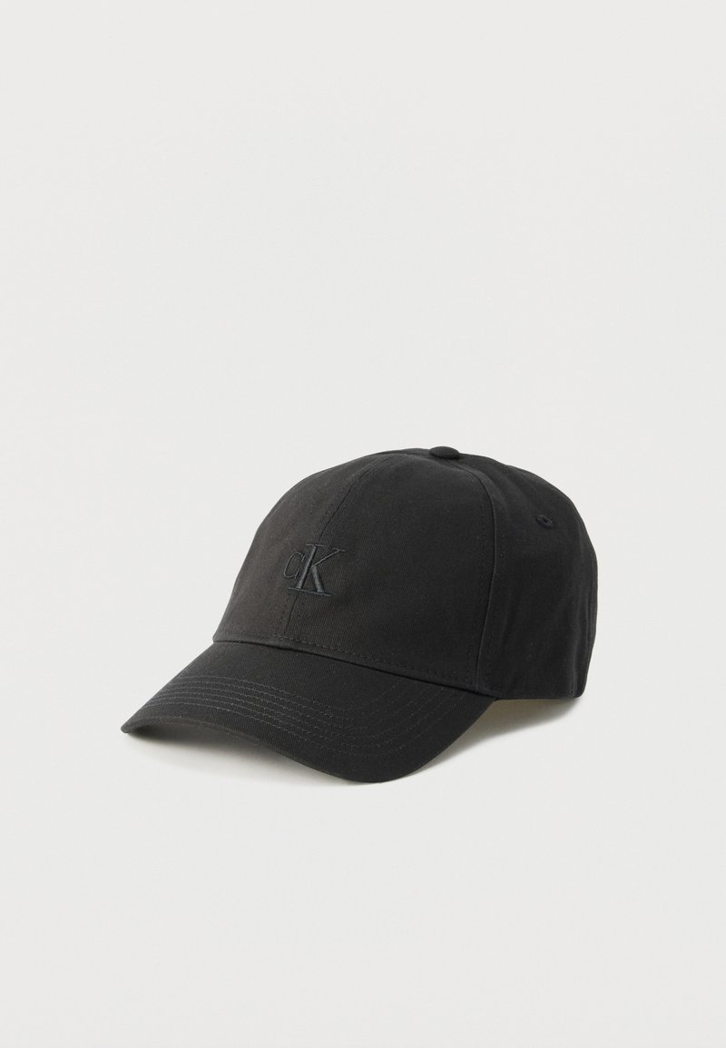 Μαύρο καπέλο μπέιζμπολ με καμπύλη γείσο και διακριτικό κεντημένο λογότυπο "cK" μπροστά, εμφανίζεται σε απλό λευκό φόντο.
