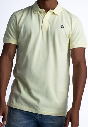 Lichtgele polo met korte mouwen, gemaakt van katoen. Heeft een klassieke kraag en een klein geborduurd logo op de borst. Glad textuur.