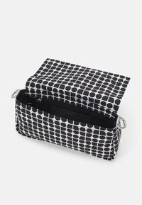 Borsa in tessuto con motivo bianco e nero, di forma rettangolare, accessori in metallo argentato e apertura superiore che rivela una tasca interna.