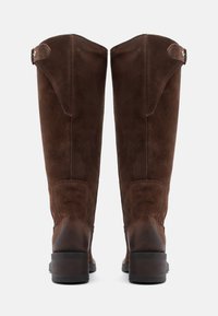 Rjavi semiš škornji do kolen z rahlim petom, opremljeni z bočnim trakom z metalno zaponko in gladkim, teksturiranim zaključkom.