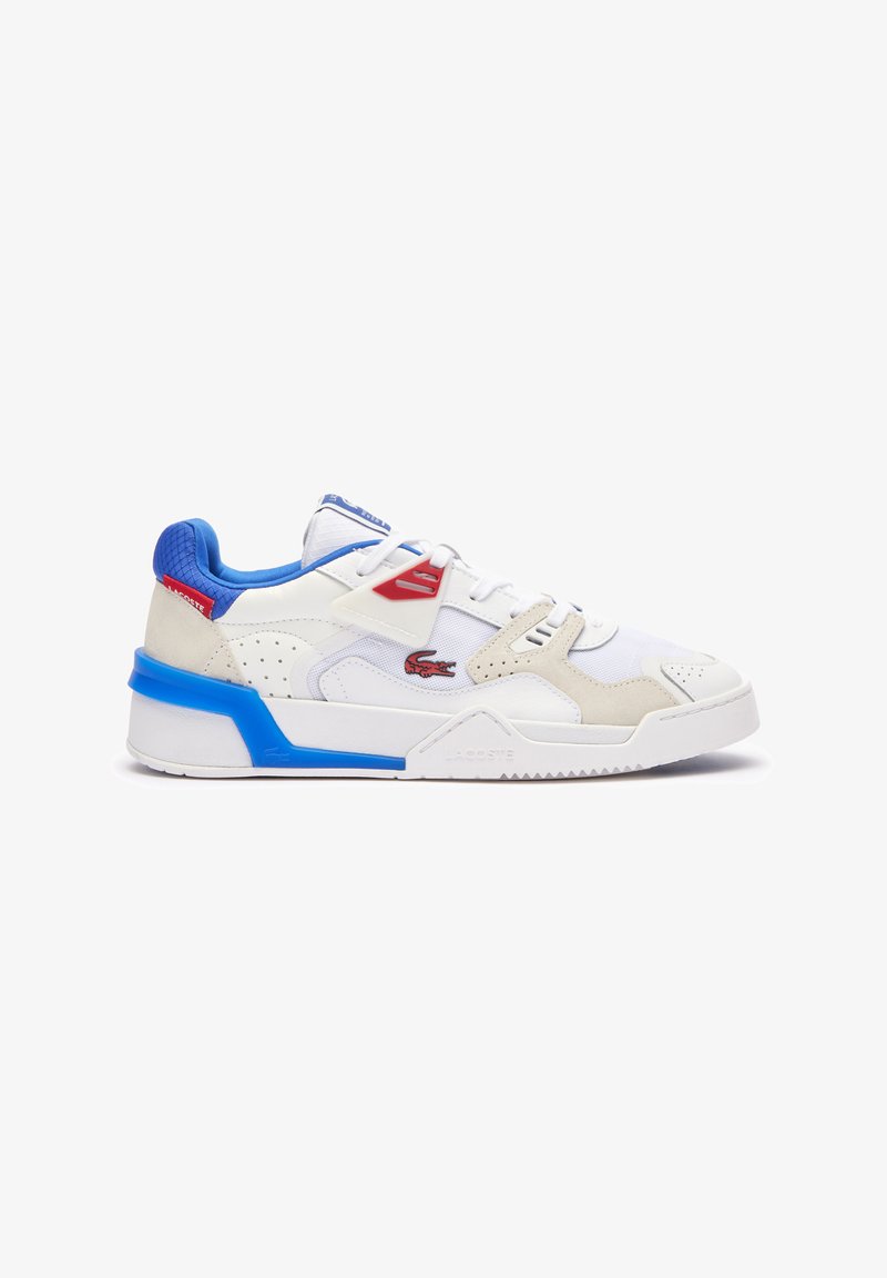 Zapatillas Lacoste con parte superior de cuero blanco, acentos en azul y rojo, detalles perforados y una suela blanca gruesa con un contraetiqueta azul.