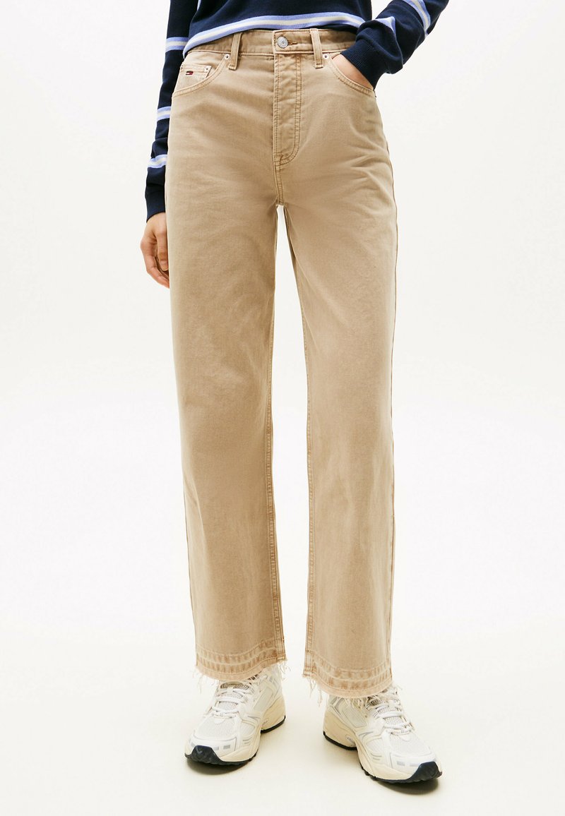 Vaqueros de pierna ancha beige con dobladillo deshilachado, hechos de una mezcla de algodón. Presenta cinco bolsillos y detalles de costura en contraste.