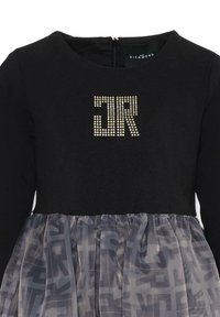 Czarna sukienka z długim rękawem, z teksturowanym gorsetem i przezroczystą, wzorzystą szarą spódnicą. Z przodu ozdobiona akcentem z kryształków "JR". Ukryty zamek błyskawiczny.