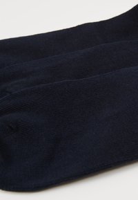 Marineblaue Socken aus weichem, strukturiertem Stoff, mit einer glatten Oberfläche und einem klassischen Design mit einem gerippten Bündchen.