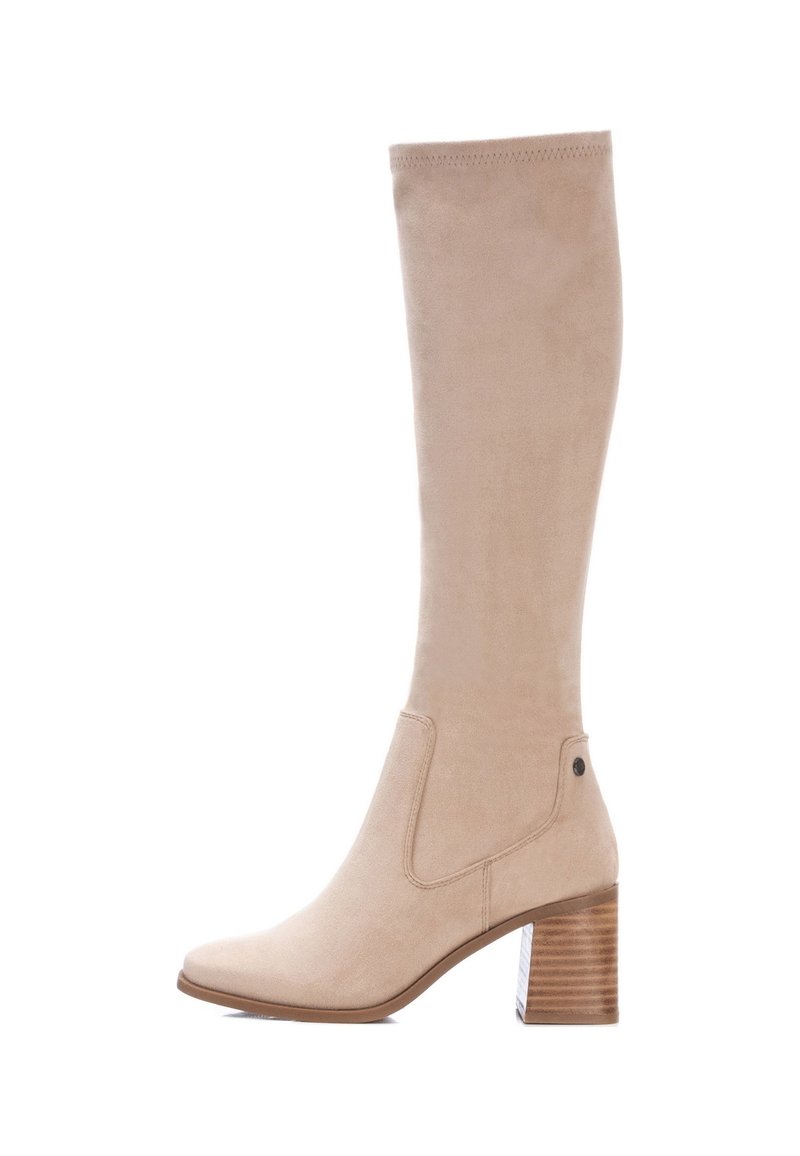 Beżowe zamszowe kozaki za kolano z wąskim noskiem, elastycznymi panelami po bokach i słupkowym obcasem z poziomymi rowkami. Płaska podeszwa zapewniająca stabilność.