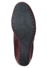 Zapato de ante burdeos con suela de goma negra texturizada que presenta un patrón geométrico y branding. Parte superior lisa con un diseño elegante y aerodinámico.