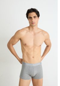 Szürke boxer alsónadrág puha textúrával és rugalmas derékkal, amelyen a "TOMMY HILFIGER" logó látható. Testhez simuló fazon, combközép hosszúságú.