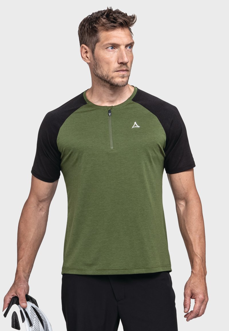 Grünes und schwarzes kurzärmeliges Sport-Shirt mit Reißverschluss am Hals, strukturiertem Stoff und einem Logo auf der Brust. Ein Mann hält einen Helm.