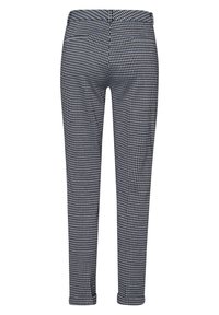 Spodnie w czarno-białą kratkę hounds-tooth z elastycznym pasem, slim fit i długości do kostek. Brak widocznych kieszeni.