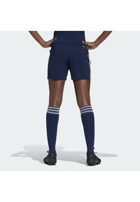 Laivaston siniset urheilushortsit valkoisilla sivuraidoilla, yhdistettynä polven korkeisiin laivaston sinisiin sukkiin, joissa on kolme valkoista raitaa yläosassa, käytetty mustien nappiksen kanssa.