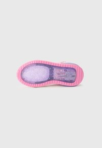 Die Schuhsohle verfügt über einen durchsichtigen lila Abschnitt mit Blasen, eine pinke Gummisohle und eine geriffelte Textur für besseren Halt, die ein lebhaftes Design hervorhebt.