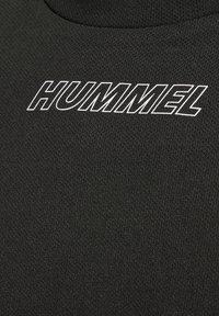 Zwart sportstof met een gestructureerde afwerking; opvallend wit "HUMMEL" logo over de voorkant weergegeven in vetgedrukte typografie.
