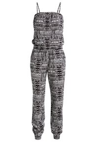 Combinaison sans manches à motifs géométriques noir et blanc, avec bretelles spaghetti, taille cintrée et poignets élastiqués.