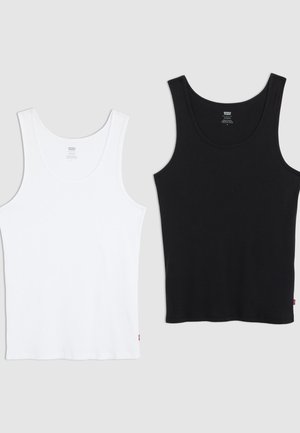 Two cotton tank tops, one white and one black, each with a ribbed texture, round neck, and a small red logo on the hem.
