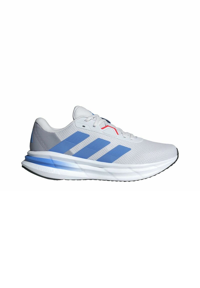 Baskets de sport gris clair avec accents bleus, tige en mesh, trois bandes horizontales et semelle rembourrée marquée "CLOUDFOAM."