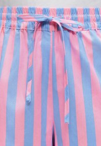 Σορτς με ελαστική μέση, με εναλλασσόμενες κάθετες ροζ και μπλε ρίγες και δεμένο κορδόνι στο μπροστινό κέντρο.