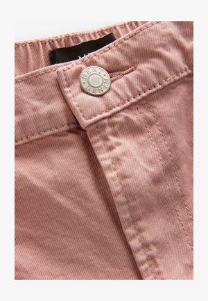 Rosa Denim-Stoff mit feiner Textur, ausgestattet mit einem silbernen Druckknopf mit der Aufschrift "NEXT" und sauberer Naht entlang der Ränder.