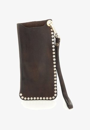 Braccialetto in pelle marrone scuro con borchie argentate lungo i bordi e un gancio in metallo attaccato a una cinghia di pelle.