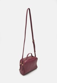 Borsa a tracolla bordeaux con texture a rallenti, zip in tonalità oro e tracolla regolabile. Presenta una maniglia superiore e una forma compatta.