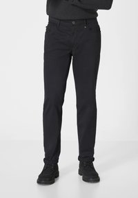 Schwarze Baumwollmischungshosen mit schmaler Passform, die über vordere Taschen, einen kleinen glanzenden Hardware-Akzent und umgeschlagene Bündchen verfügen.