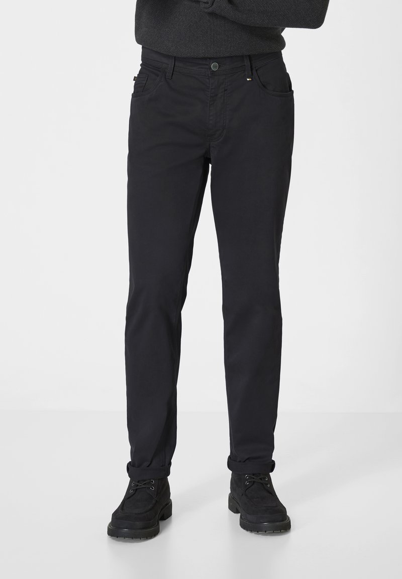 Schwarze Baumwollmischungshosen mit schmaler Passform, die über vordere Taschen, einen kleinen glanzenden Hardware-Akzent und umgeschlagene Bündchen verfügen.