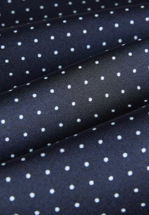 Nawigacyjny materiał z małymi białymi kropkami, gładka tekstura, prawdopodobnie z poliestru lub jedwabiu, złożony w warstwy.