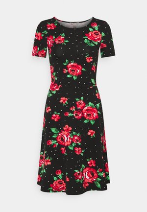 Vestido negro de manga corta con estampado floral rojo y rosa y pequeñas lunares blancas, largo hasta la rodilla, cintura ajustada, escote redondo.