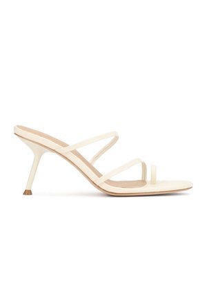 Εκρού πέδιλο με ψηλό τακούνι, λεπτά λουράκια, θηλιά για τα δάχτυλα και λεπτό στιλέτο τακούνι σε λευκό φόντο.