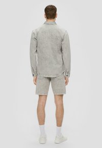 Grijze denim shirt met lange mouwen en knoopmanchetten, gecombineerd met bijpassende grijze denim shorts. Beide hebben een vervaagde afwerking en een casual pasvorm.