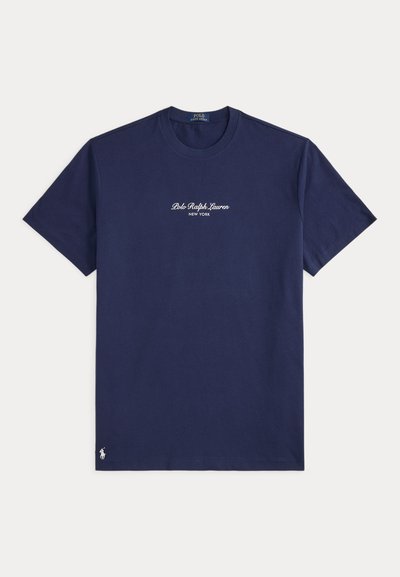 Μπλε σκούρο T-shirt με κοντά μανίκια, με κείμενο "Polo Ralph Lauren New York" στο στήθος και μικρό λευκό λογότυπο παίκτη πόλο κοντά στο κάτω άκρο.