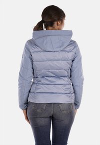 Giacca imbottita azzurra chiara con cappuccio, caratterizzata da sezioni orizzontali trapuntate, una superficie liscia e lucida, e polsini elasticizzati.