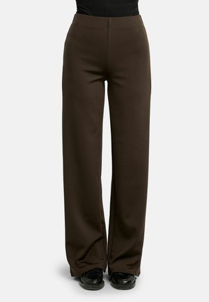 Pantalon marron taille haute à jambes larges, porté avec des chaussures noires et un haut noir, montré de la taille aux pieds sur un fond uni.