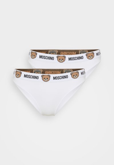 Balti kokvilnas apakšveļa ar brūnu elastīgu jostasvīru, uz kura attēlots lāča grafiks un teksts "MOSCHINO". Parādīti divi pāri.