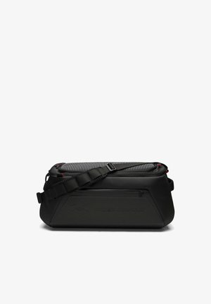 Zwarte Under Armour duffel tas met verstelbare schouderriem, voorvak met rits en gestructureerd bovenpaneel op een witte achtergrond.