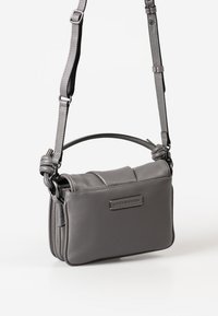 Graue Leder-Crossbody-Tasche mit strukturierter Oberfläche, Obergriff, verstellbarem Schulterriemen und gestepptem Designdetail. Mit einem Logo-Patch.